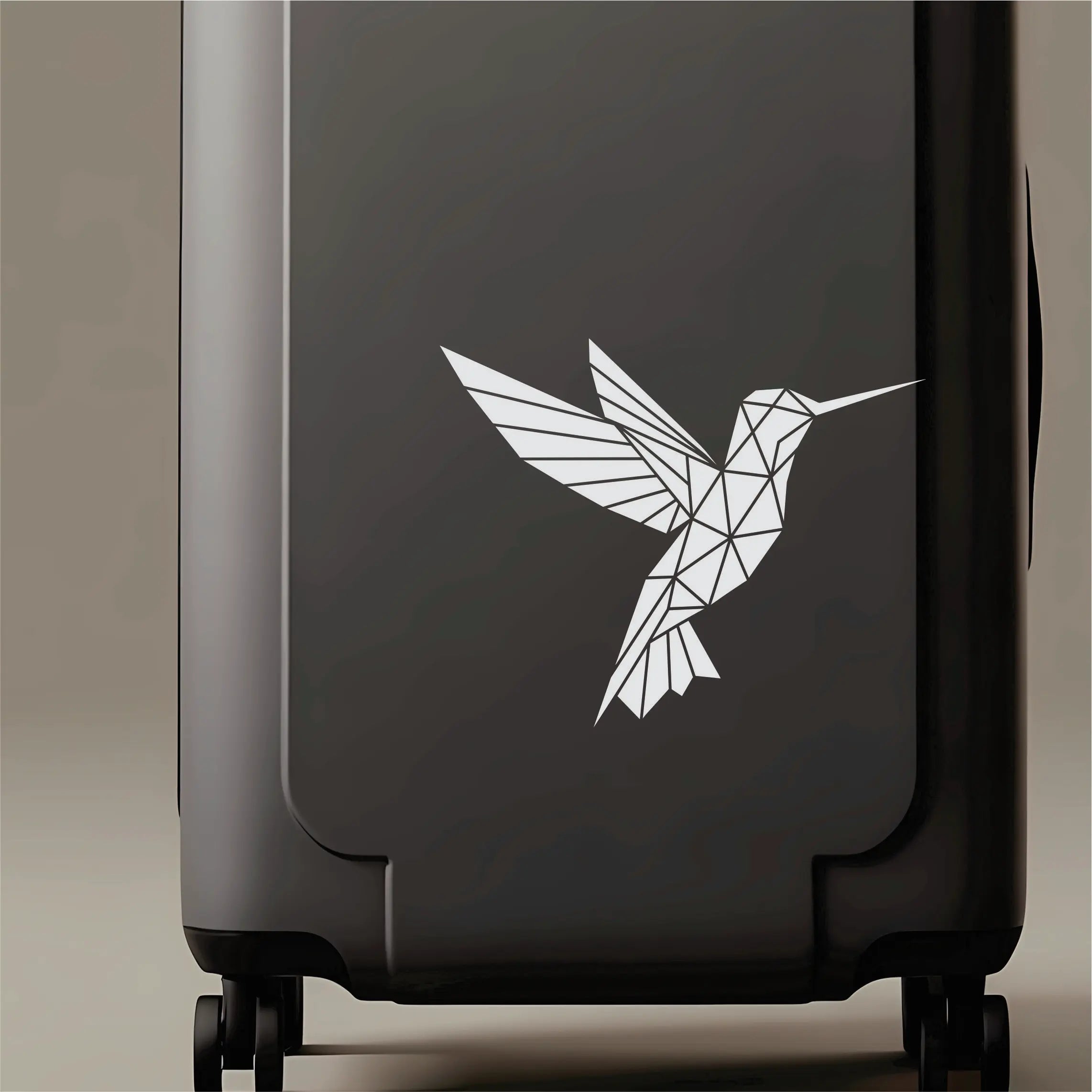 Minimal geometric hummingbird vinyl decal on laptop and mug, a clean line-bird sticker for designers, students and creative workspaces.