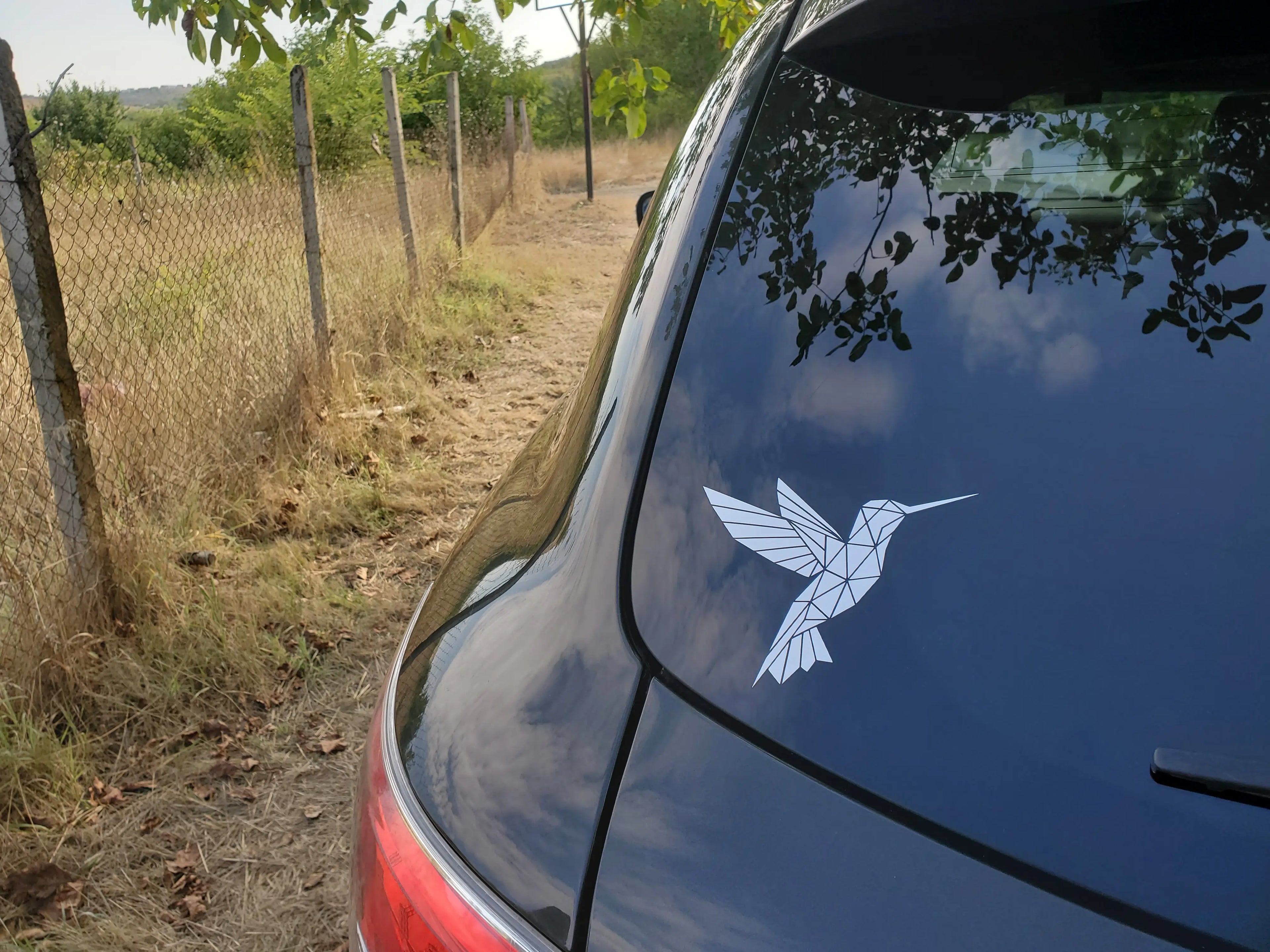 Small angular hummingbird vinyl decal with faceted wings, a contemporary bird sticker accent for sketchbooks, travel cups and tech.