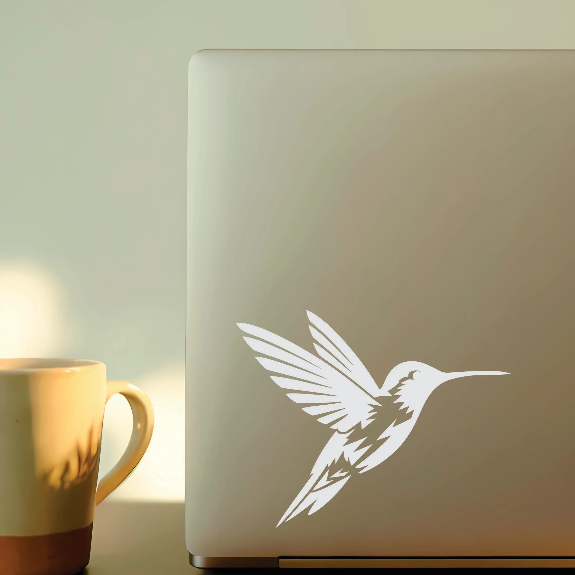 Minimal hummingbird vinyl decal shown on laptop and mug, a delicate bird sticker accent for teachers, nurses and creative everyday setups.