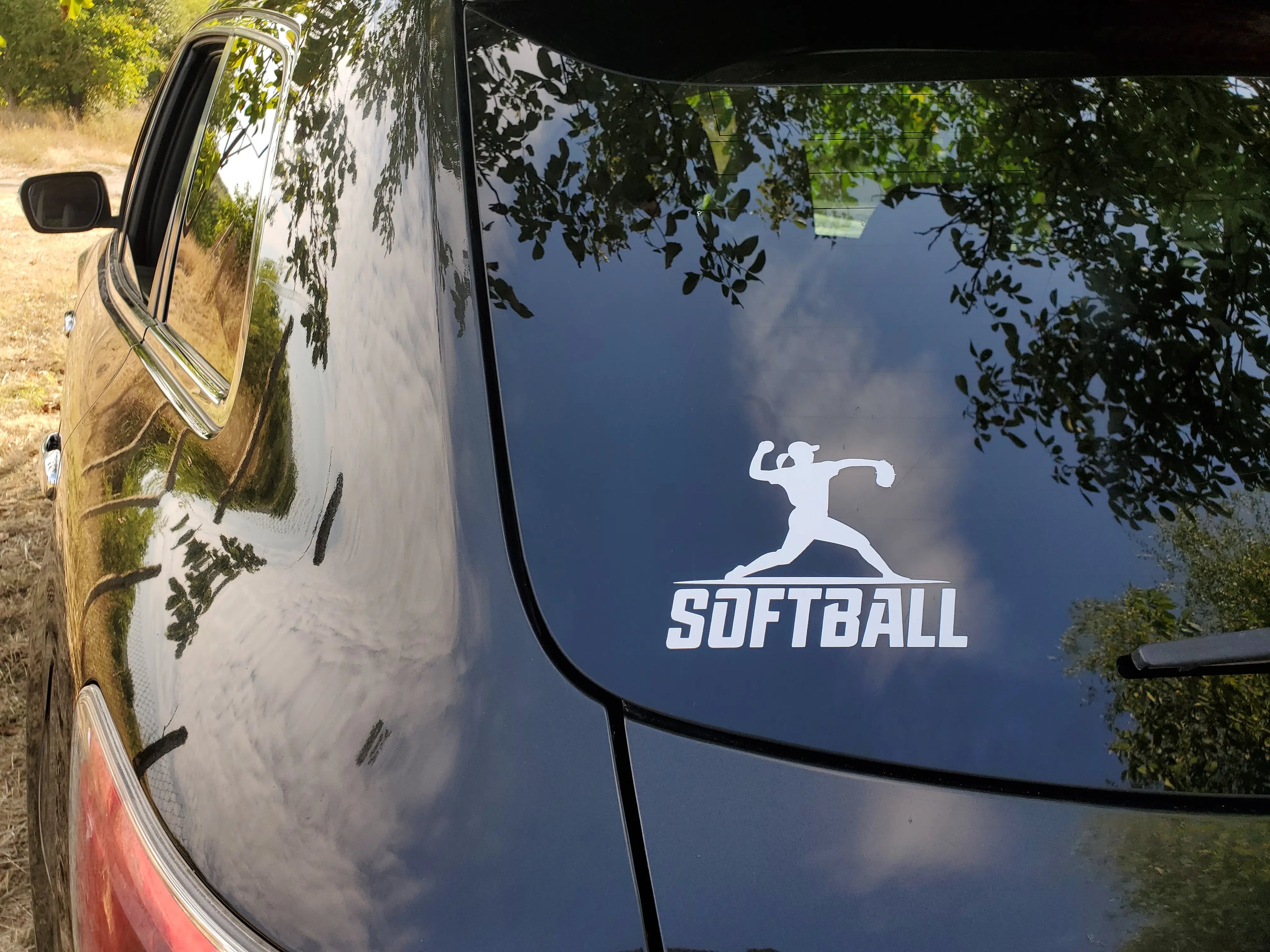 Silhouette softball player vinyl decal in throwing pose over wordmark, a focused sticker for car windows, bat bags and practice laptops.